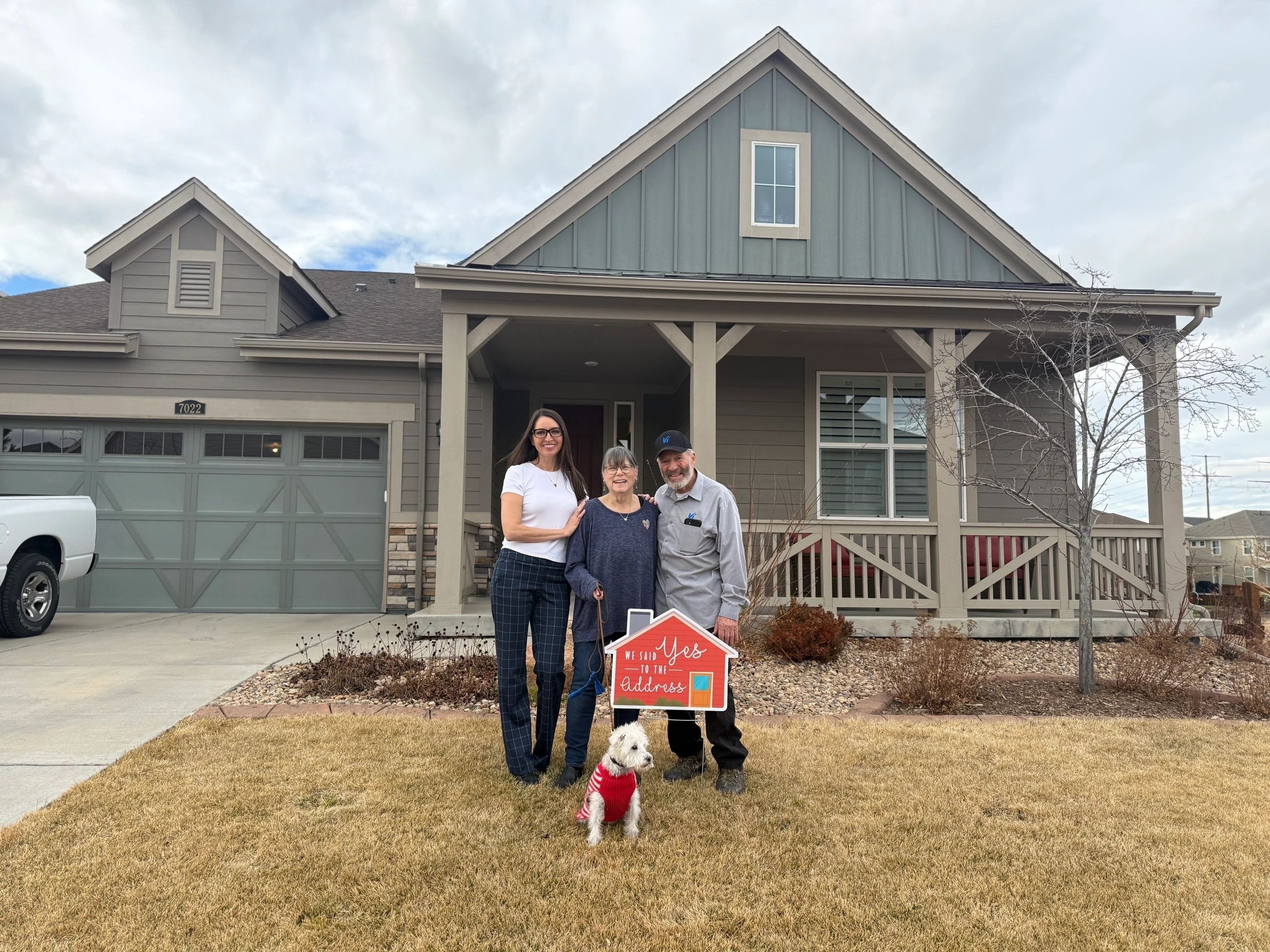 Sharon and Harry on closing day holding a new address sign